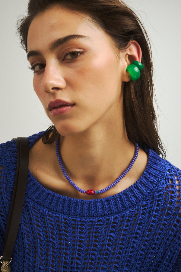 Zestawienie dwóch zielonych nausznic z koralikowym naszyjnikiem z truskawką