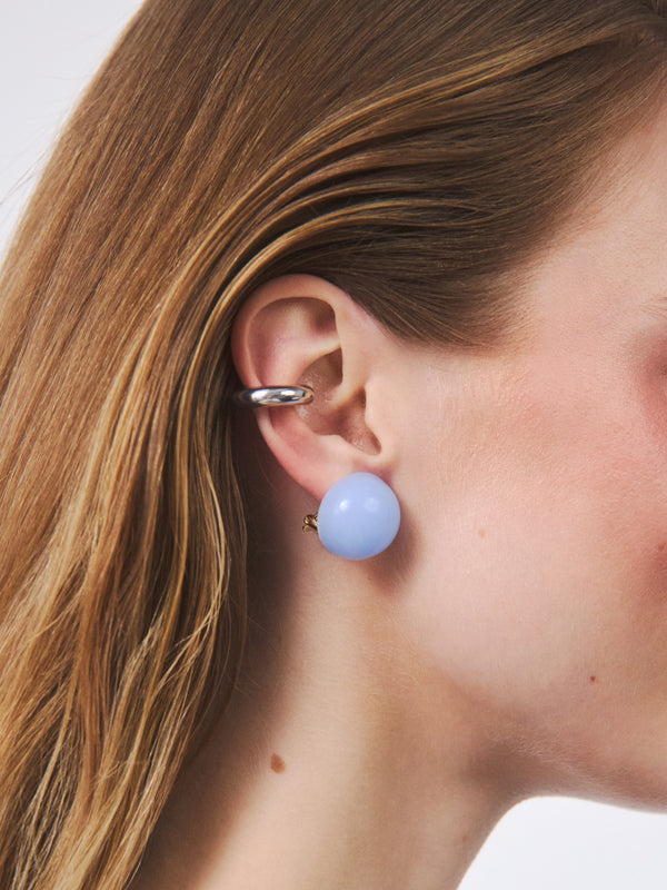 Duże, okragłe kolczyki w połączeniu ze srebrną nausznicą