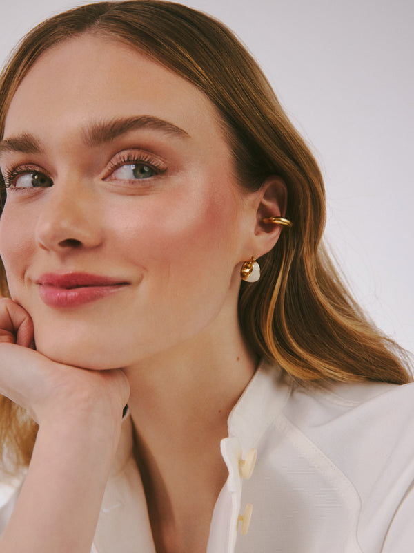 Zestawienie owalnego kolczyka z białą emalią wraz z nausznicą