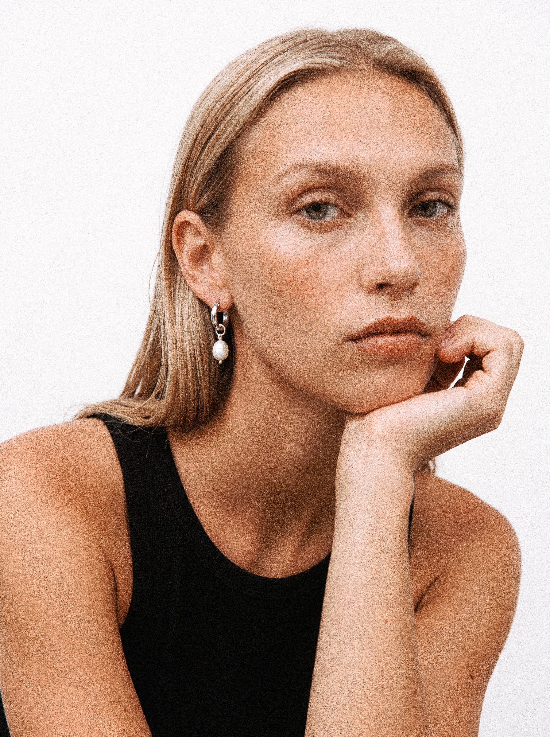 Srebrny kolczyk z zawieszką z perły hodowlanej na modelce.