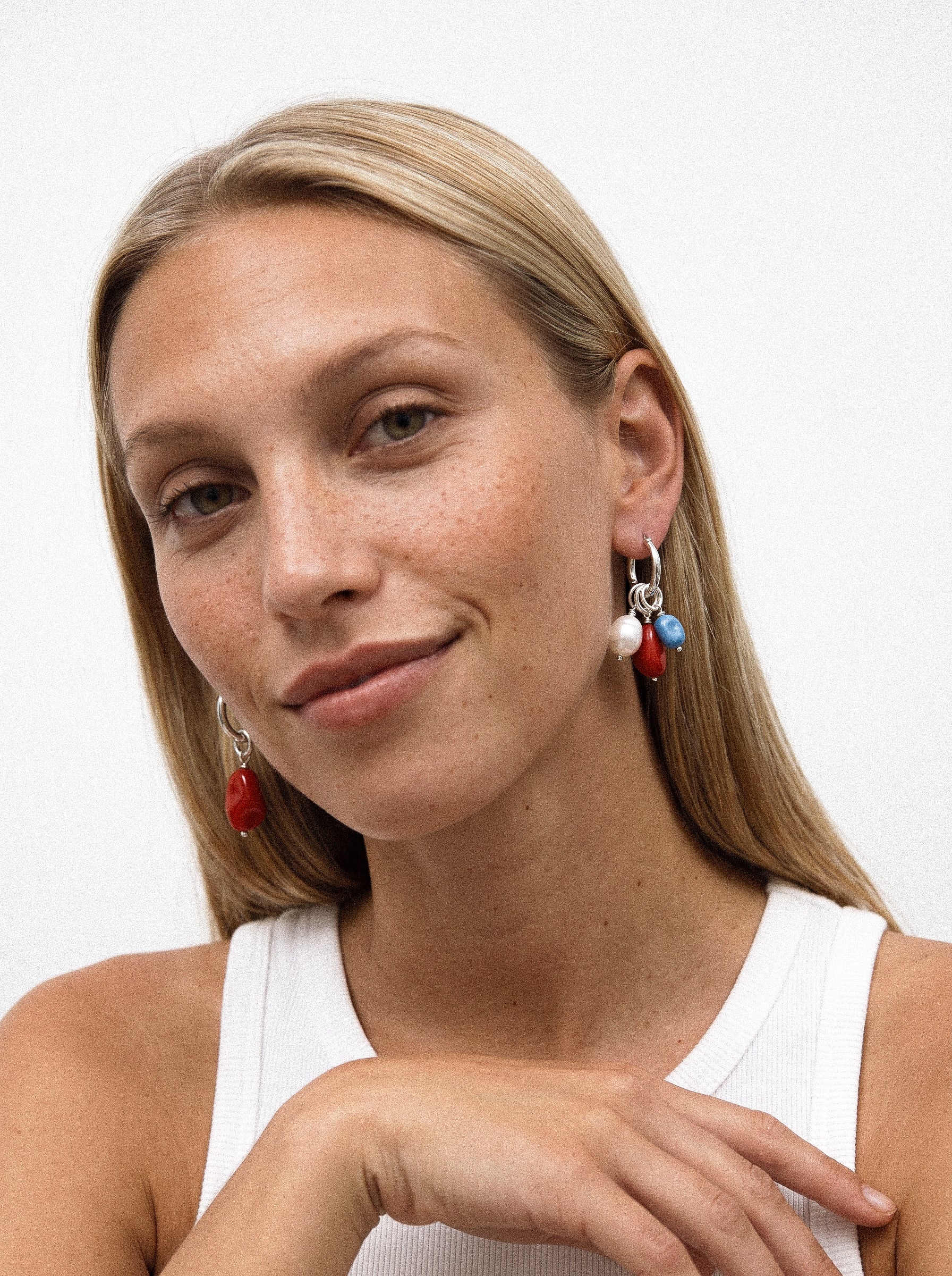 Set kolczyków z kolorowymi zawieszkami na modelce. 