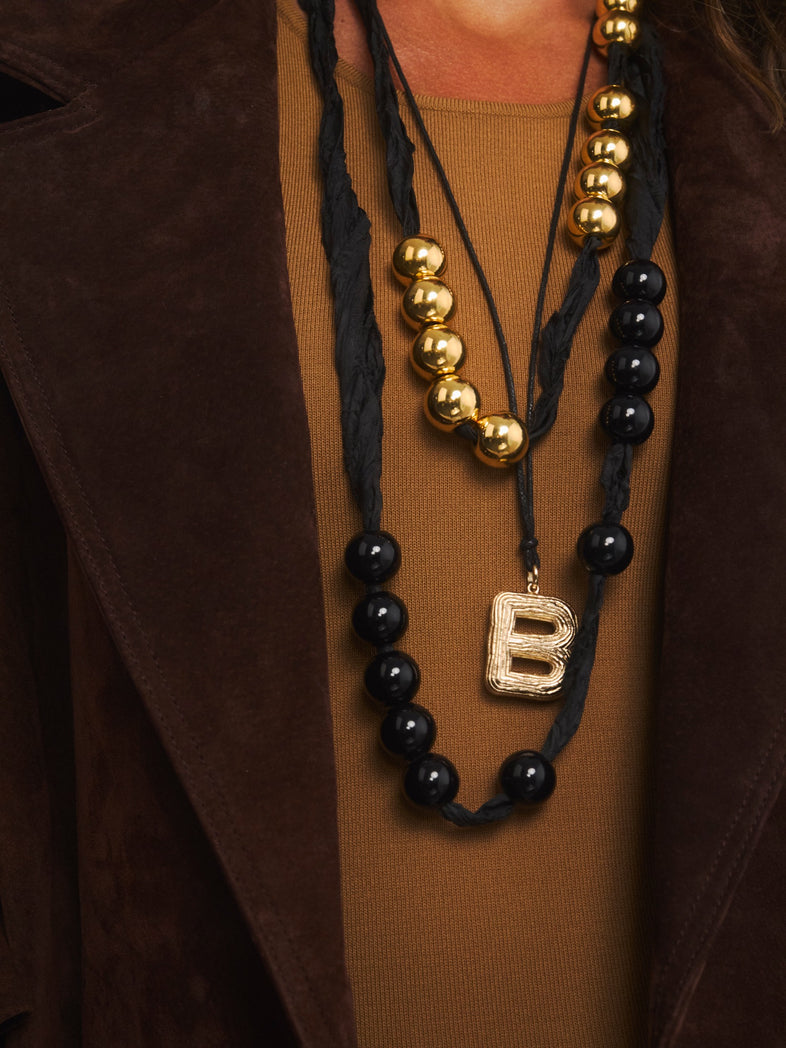  Złote korale z żywicy na czarnej wstążce w kolekcji Splash w zestawie z czarną ich wersją i naszyjnikiem z literką B 